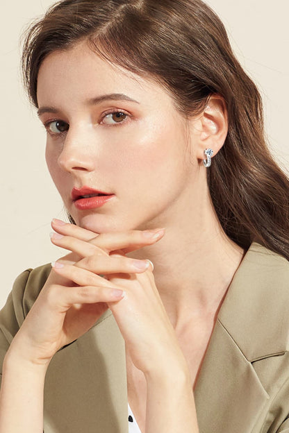 Close-up of a woman wearing earrings with a beige background