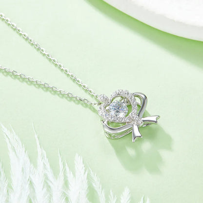 Silver necklace with a heart-shaped pendant on a light green background