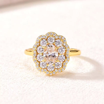 Gold ring with a large central diamond and smaller diamonds around on a light background